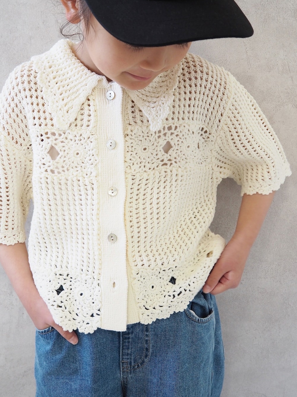 ブルー系のパンツ、ホワイト系のカーディガン/ボレロ、ブラック系のスニーカーを着用したキッズの春コーディネートの3枚目の写真