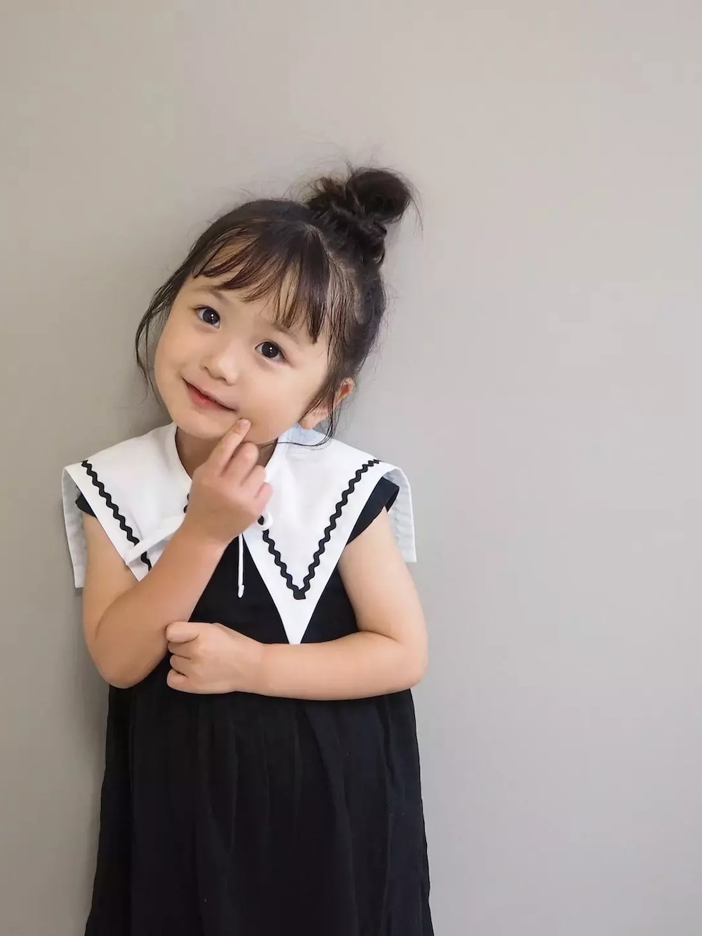 ブラック系のワンピース、ホワイト系の付け襟を着用したキッズの夏コーディネートの4枚目の写真