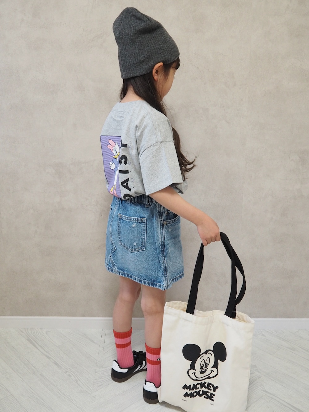 グレー系のTシャツ/カットソー、ブルー系のデニムスカート、ブラック系のスニーカーを着用したキッズの春コーディネートの3枚目の写真