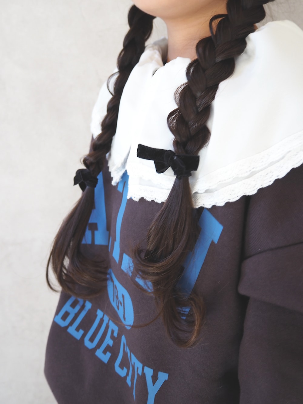 ブラウン系のスウェット、ホワイト系のシャツ/ブラウス、ブルー系のスカートを着用したキッズの冬コーディネートの4枚目の写真