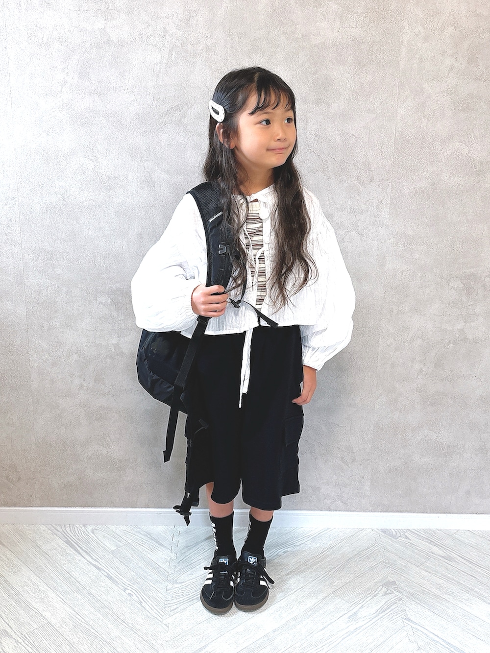 ブラック系のその他パンツ、ブラック系のスニーカー、ブラウン系のタンクトップを着用したキッズの秋コーディネートの2枚目の写真