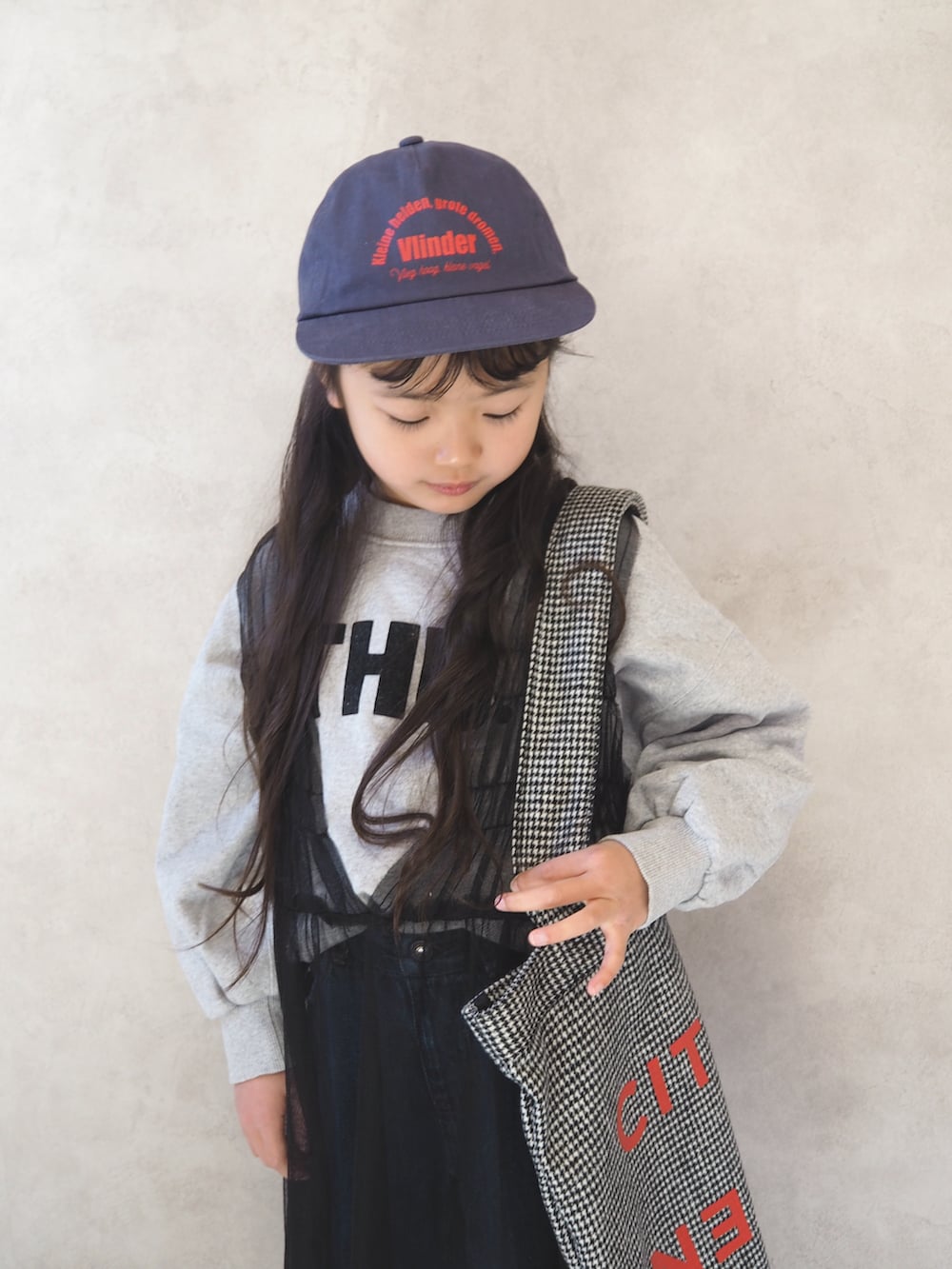 グレー系のスウェット、ブラック系のトートバッグ、ブラック系のチュニックを着用したキッズの冬コーディネートの5枚目の写真