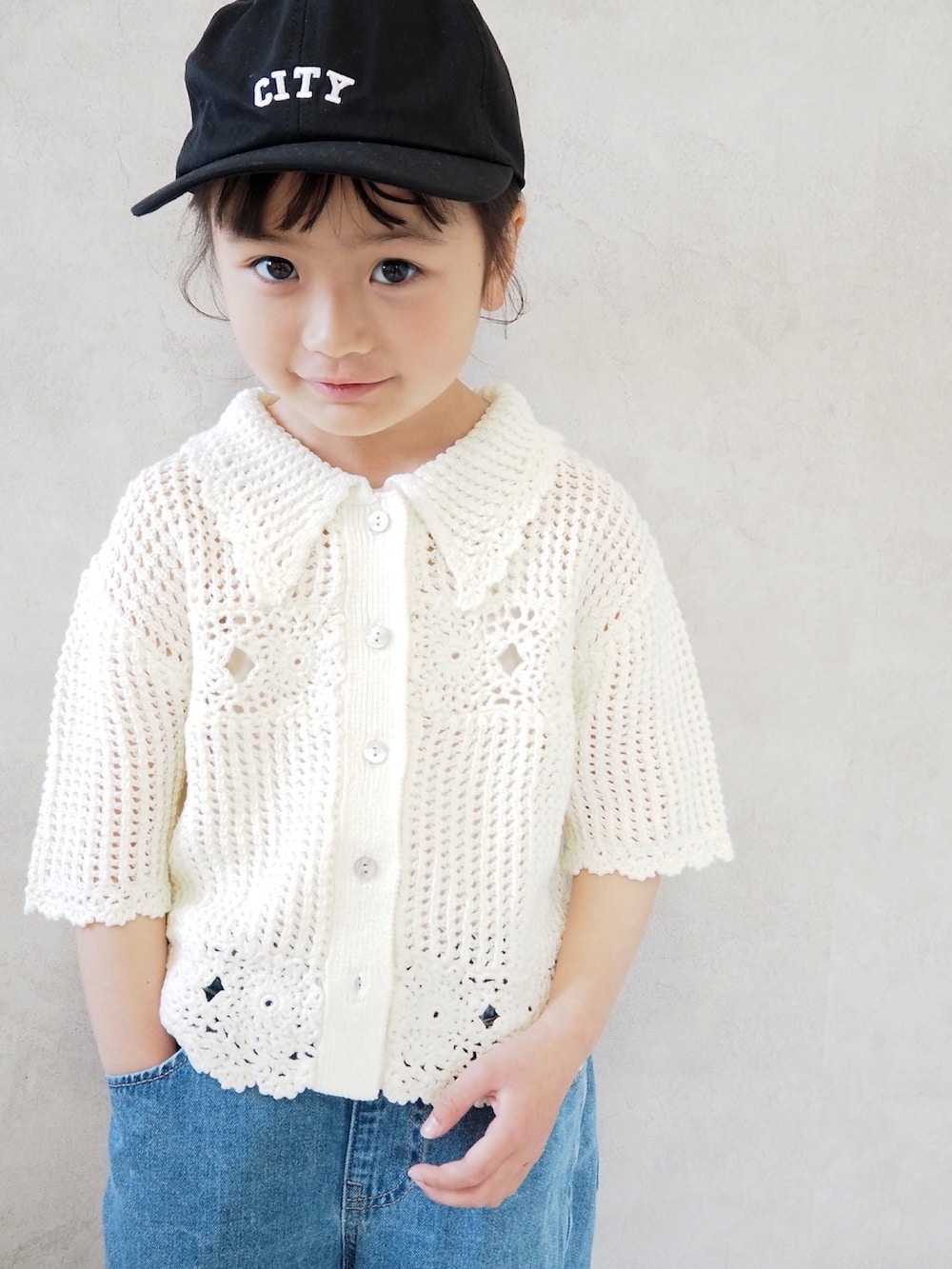 ブルー系のパンツ、ホワイト系のカーディガン/ボレロ、ブラック系のスニーカーを着用したキッズの春コーディネートの4枚目の写真