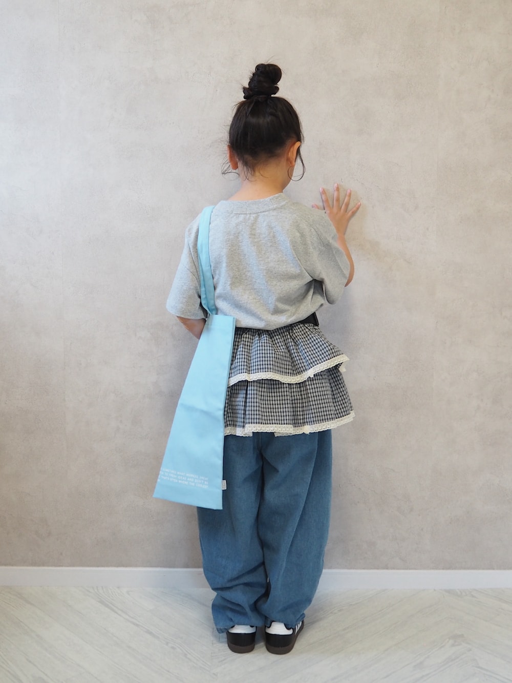 ブラック系のスニーカー、グレー系のTシャツ/カットソー、ブルー系のデニムパンツを着用したキッズの春コーディネートの4枚目の写真