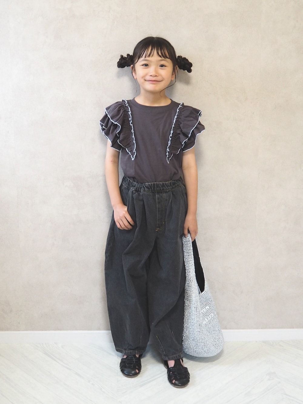 グレー系のTシャツ/カットソー、ブラック系のデニムパンツ、シルバー系のショルダーバッグを着用したキッズの夏コーディネートの2枚目の写真
