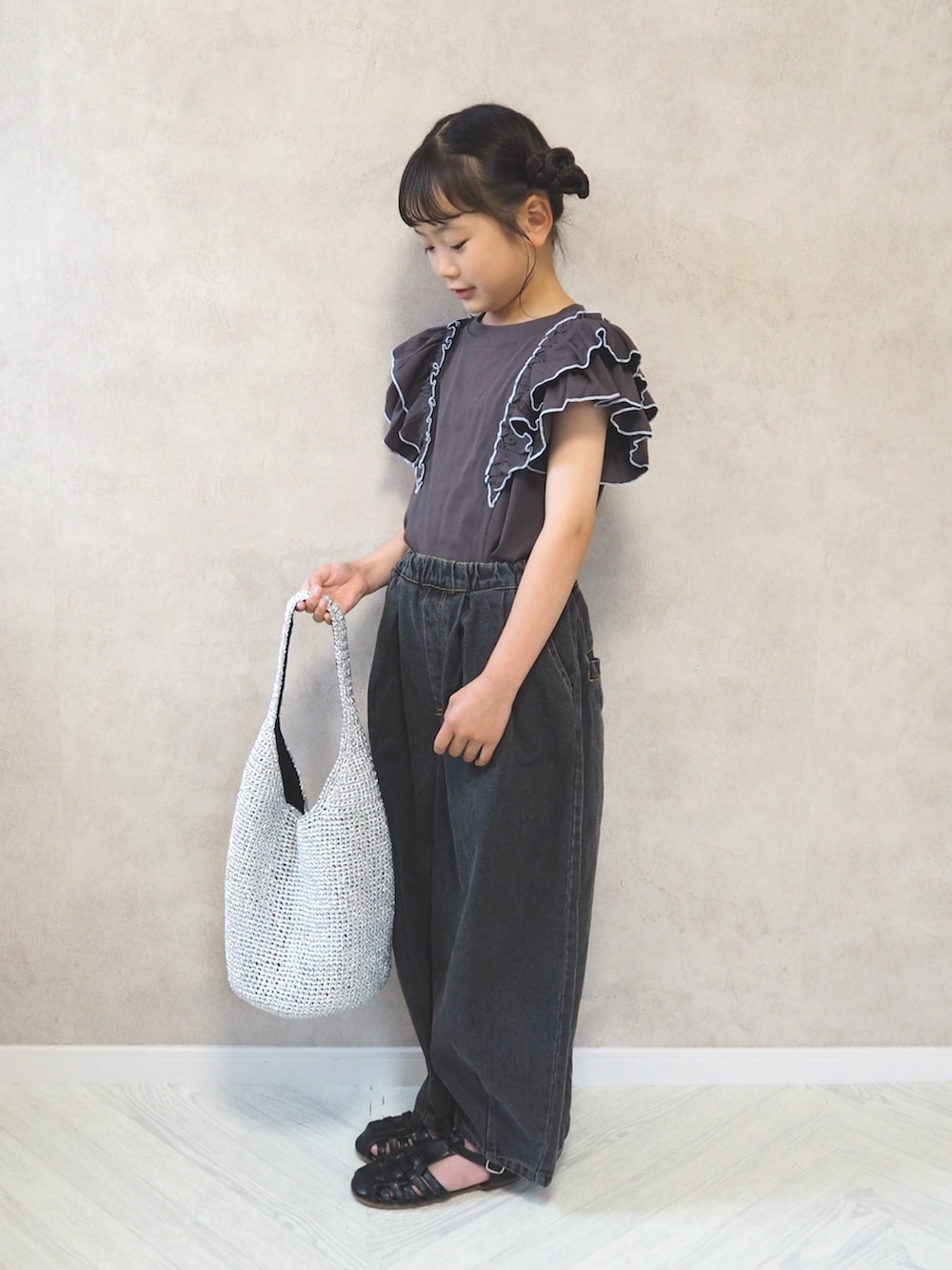 グレー系のTシャツ/カットソー、ブラック系のデニムパンツ、シルバー系のショルダーバッグを着用したキッズの夏コーディネートの3枚目の写真