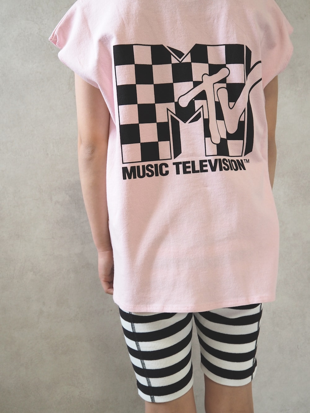 ブラック系のスニーカー、ピンク系のTシャツ/カットソー、ゴールド系のキャップを着用したキッズの春コーディネートの5枚目の写真