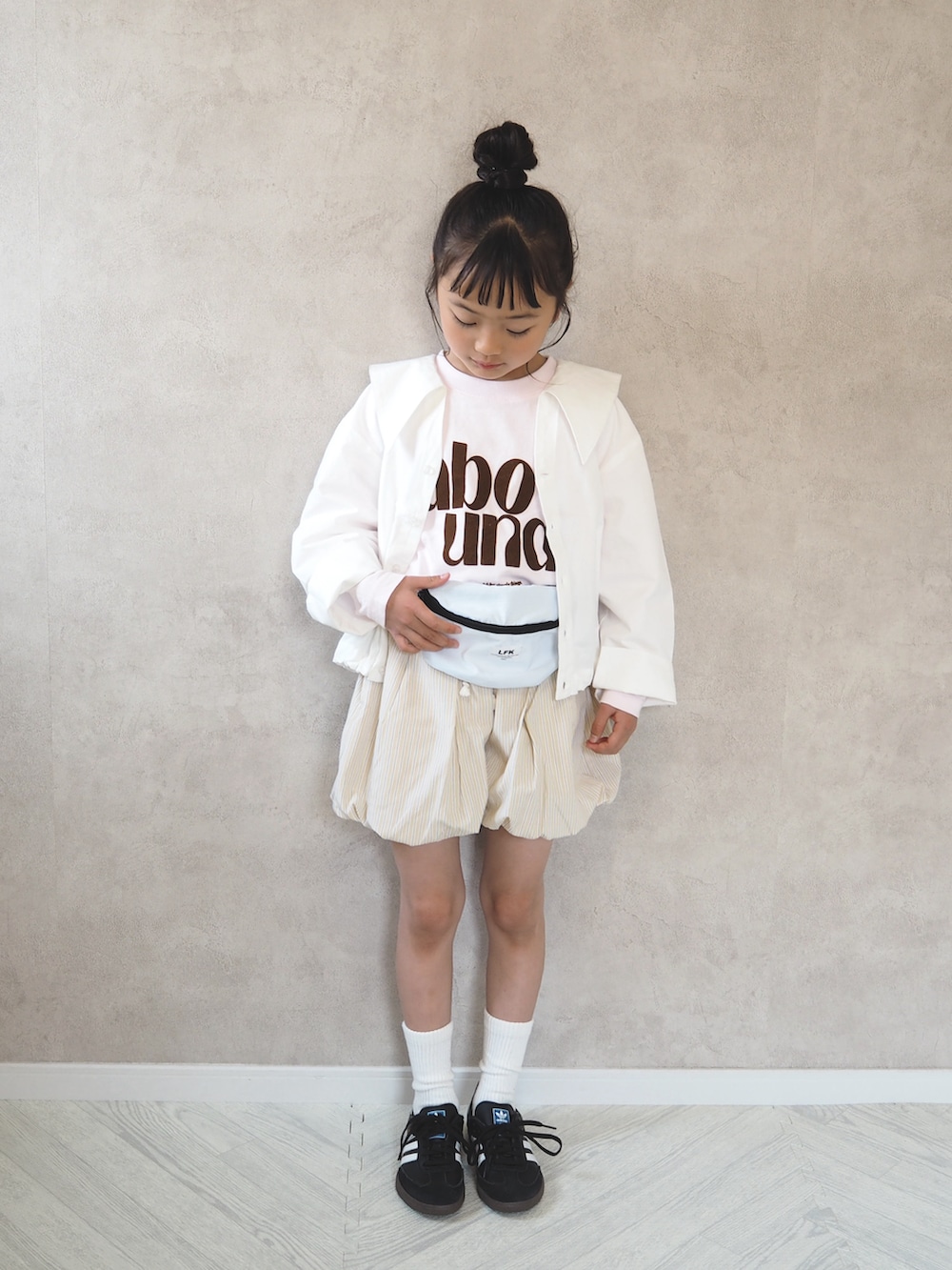 ピンク系のTシャツ/カットソー、ホワイト系のシャツ/ブラウス、ブラック系のスニーカーを着用したキッズの春コーディネートの2枚目の写真