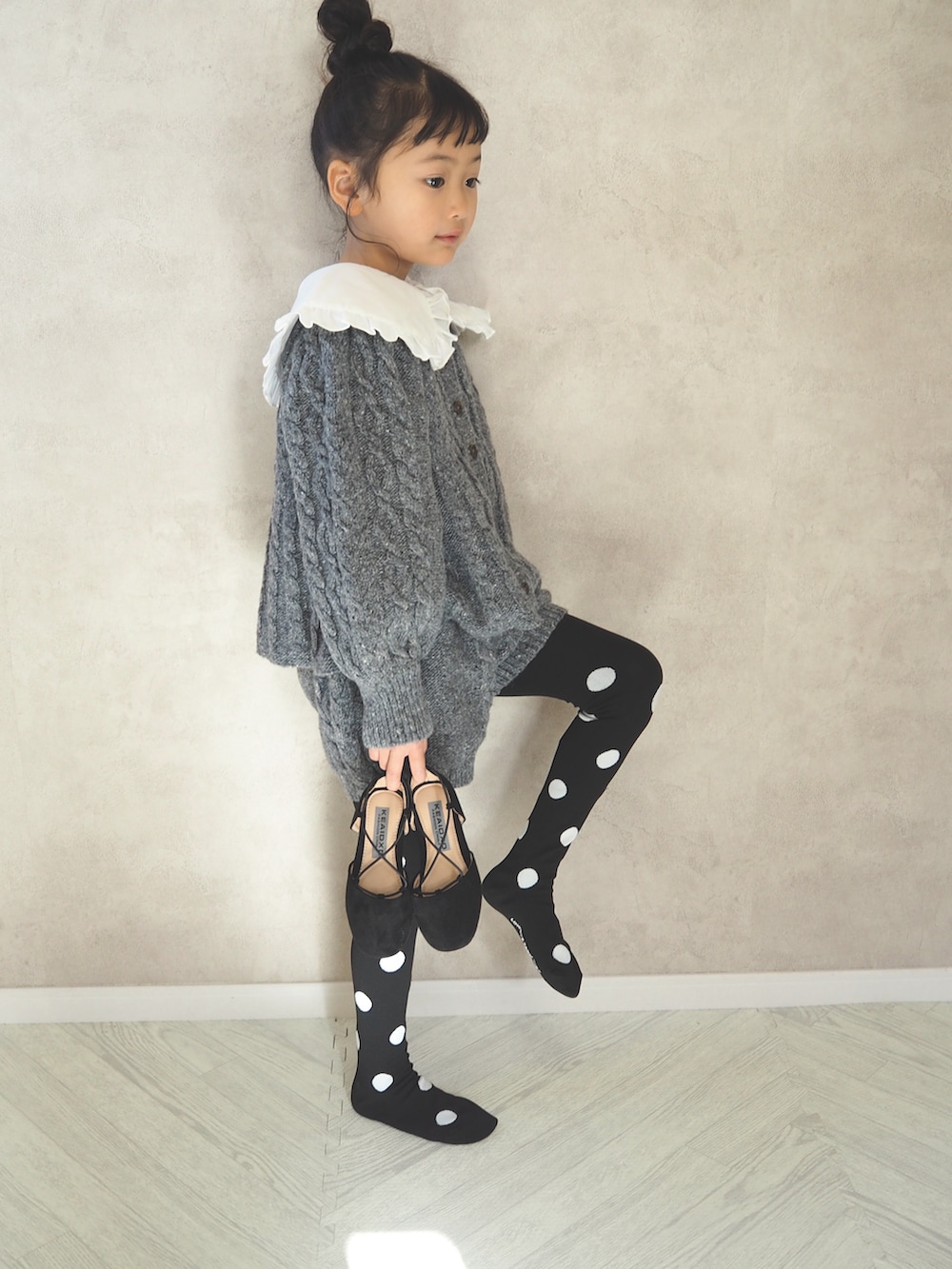 グレー系のニット/セーター、ホワイト系のシャツ/ブラウス、グレー系のその他パンツを着用したキッズの冬コーディネートの3枚目の写真