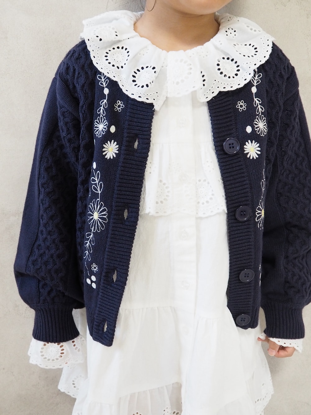 ホワイト系のワンピース、ブルー系のカーディガン/ボレロ、レッド系のソックス/靴下を着用したキッズの秋コーディネートの5枚目の写真