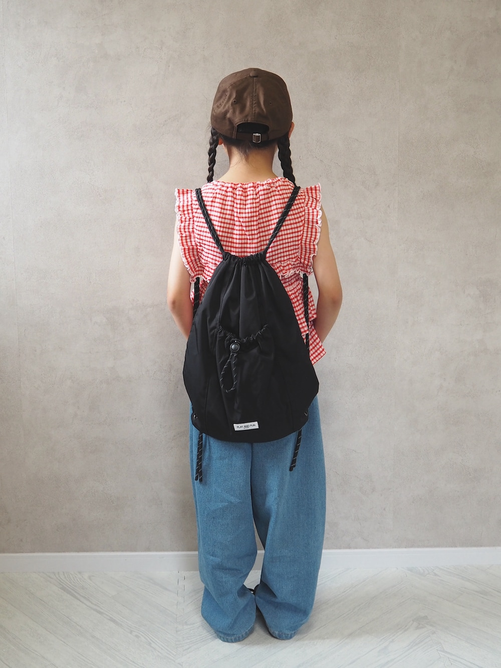 ブラック系のスニーカー、レッド系のTシャツ/カットソー、ブルー系のデニムパンツを着用したキッズの夏コーディネートの4枚目の写真