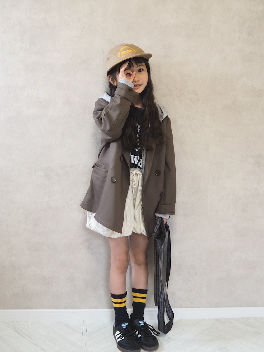 ブラウン系のテーラードジャケット、ブラック系のスニーカー、グレー系のパーカーを着用したキッズの春コーディネートの4枚目の写真