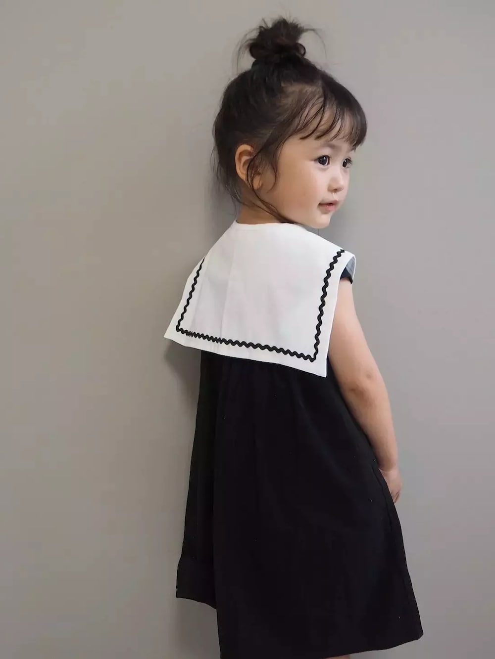 ブラック系のワンピース、ホワイト系の付け襟を着用したキッズの夏コーディネートの3枚目の写真
