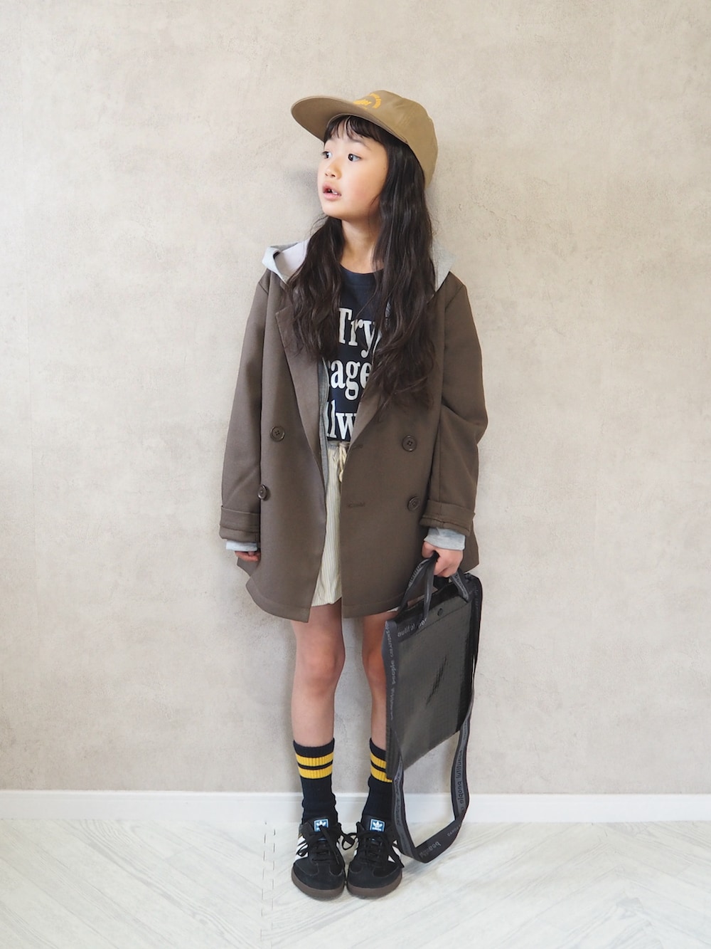 ブラウン系のテーラードジャケット、ブラック系のスニーカー、グレー系のパーカーを着用したキッズの春コーディネートの3枚目の写真