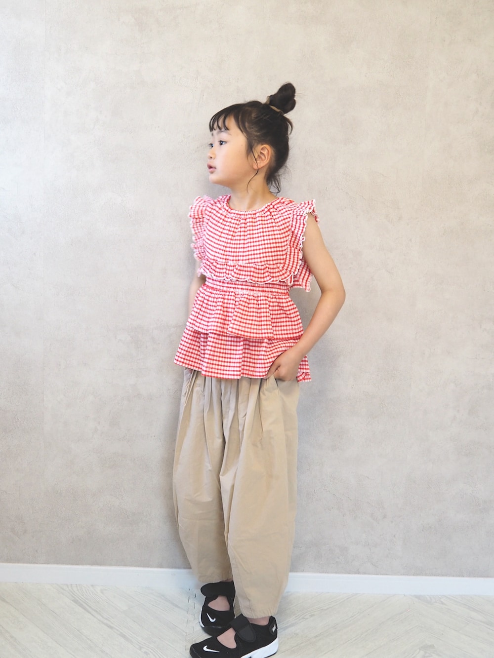 ベージュ系のその他パンツ、レッド系のTシャツ/カットソー、ブラック系のスニーカーを着用したキッズの夏コーディネートの3枚目の写真