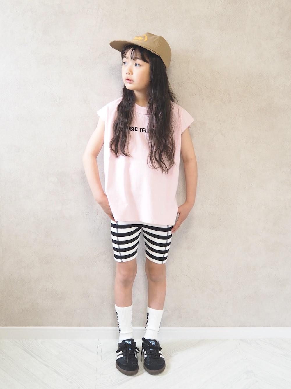 ブラック系のスニーカー、ピンク系のTシャツ/カットソー、ゴールド系のキャップを着用したキッズの春コーディネートの2枚目の写真