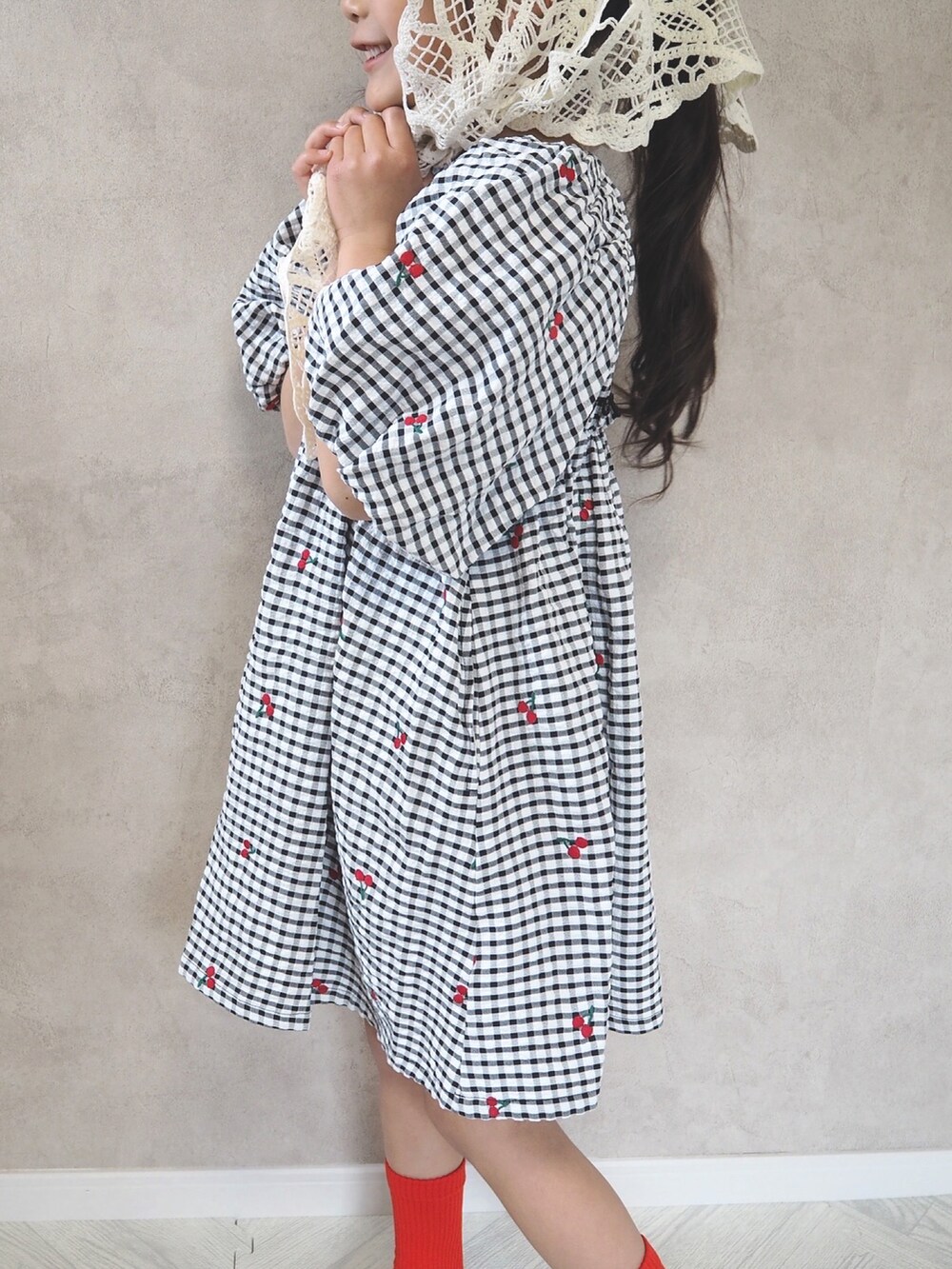 ブラック系のワンピース、レッド系のソックス/靴下、ブルー系のキャップを着用したキッズの春コーディネートの4枚目の写真