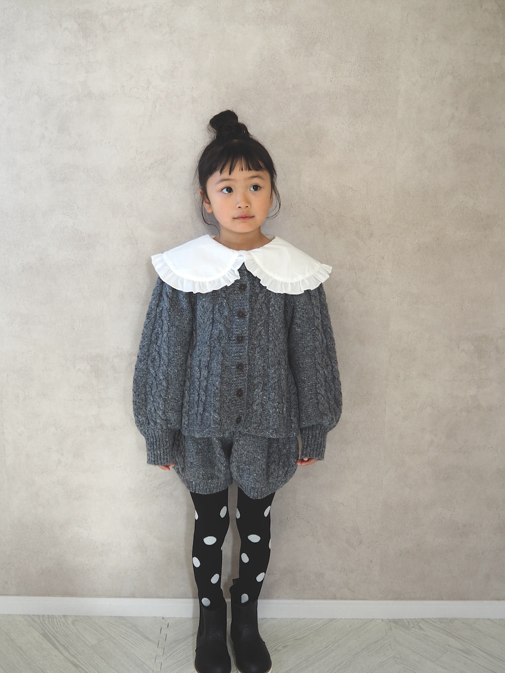 グレー系のニット/セーター、ホワイト系のシャツ/ブラウス、グレー系のその他パンツを着用したキッズの冬コーディネートの2枚目の写真