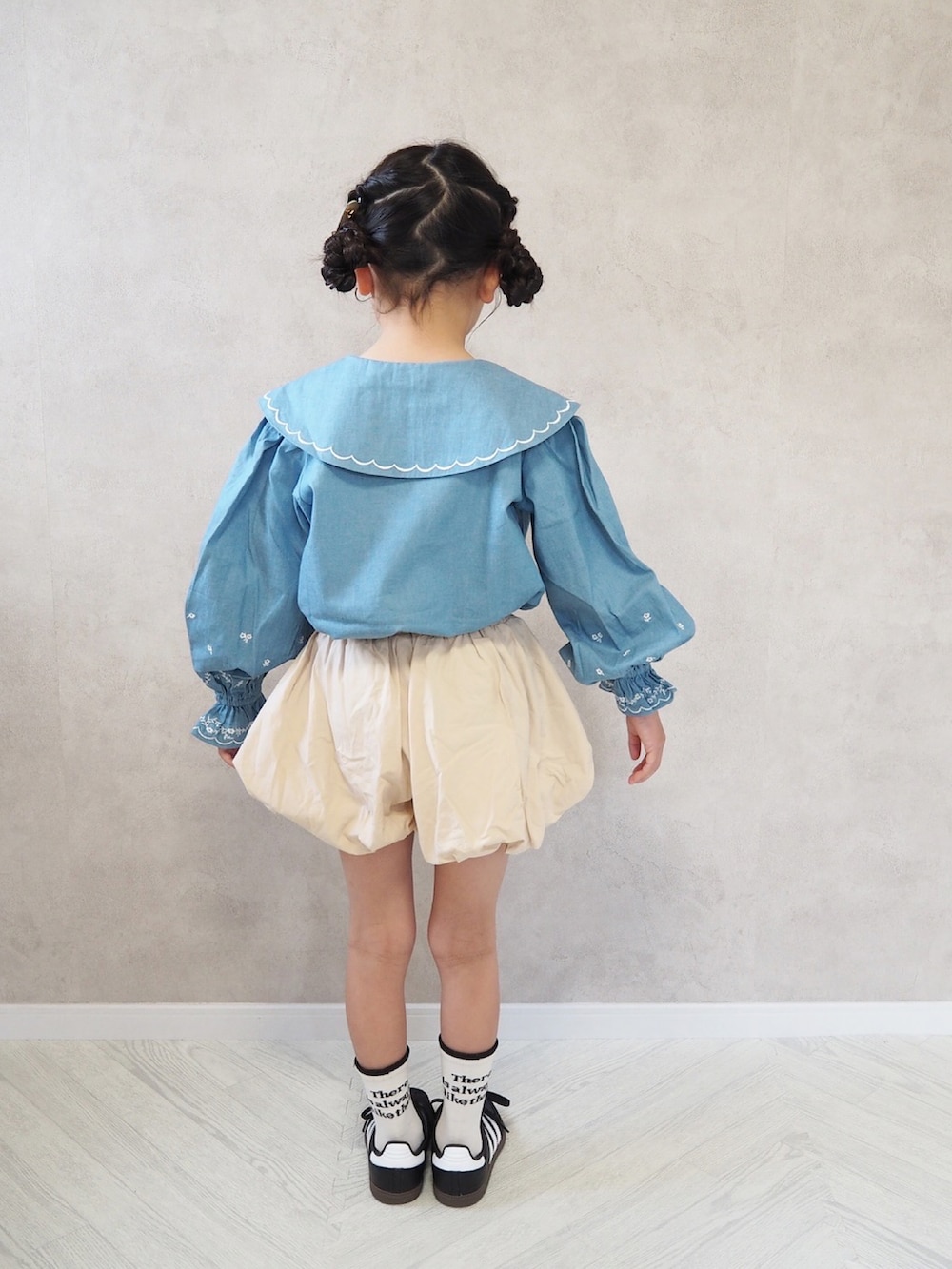 ブラック系のスニーカー、ブルー系のシャツ/ブラウスを着用したキッズの春コーディネートの3枚目の写真