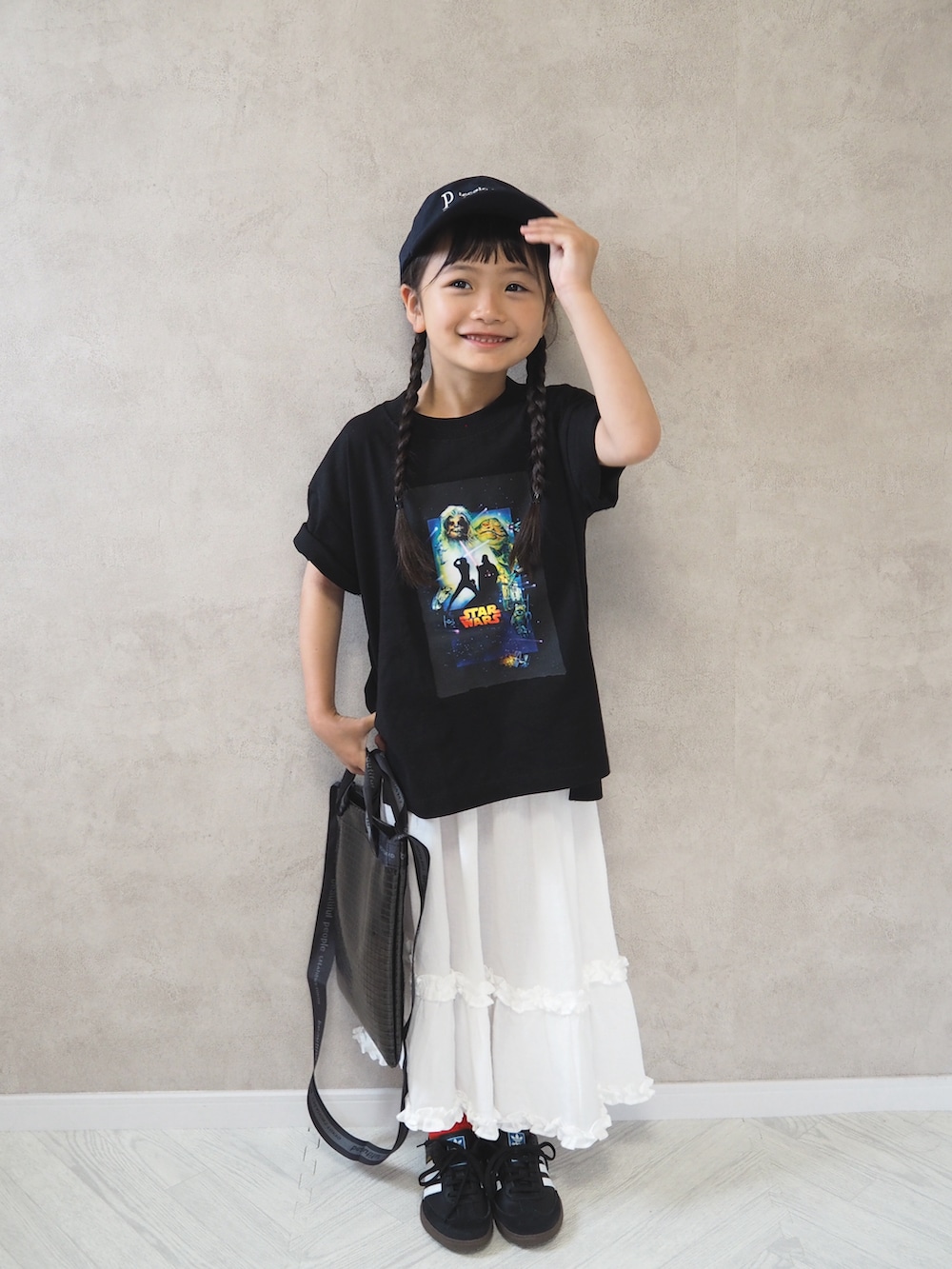 ブラック系のTシャツ/カットソー、ホワイト系のスカート、ブルー系のキャップを着用したキッズの夏コーディネートの4枚目の写真