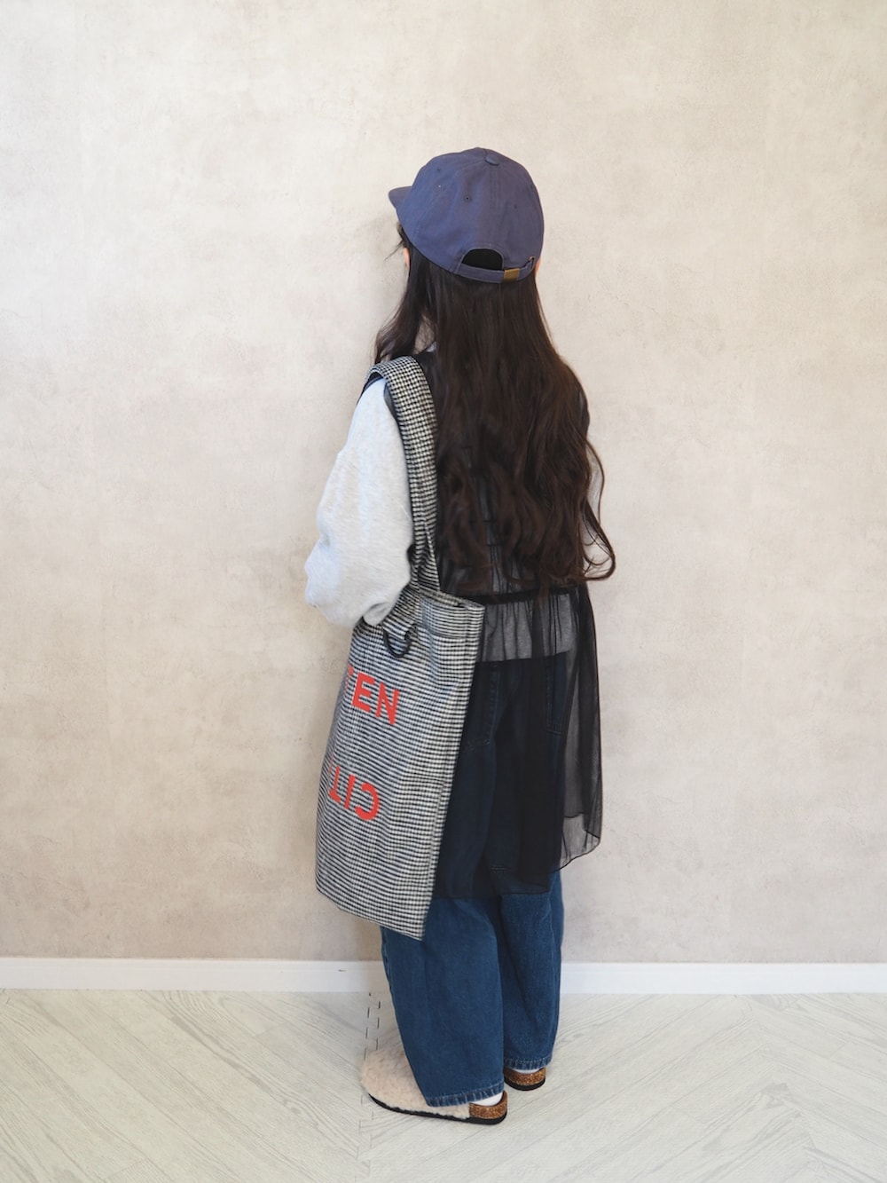 グレー系のスウェット、ブラック系のトートバッグ、ブラック系のチュニックを着用したキッズの冬コーディネートの3枚目の写真