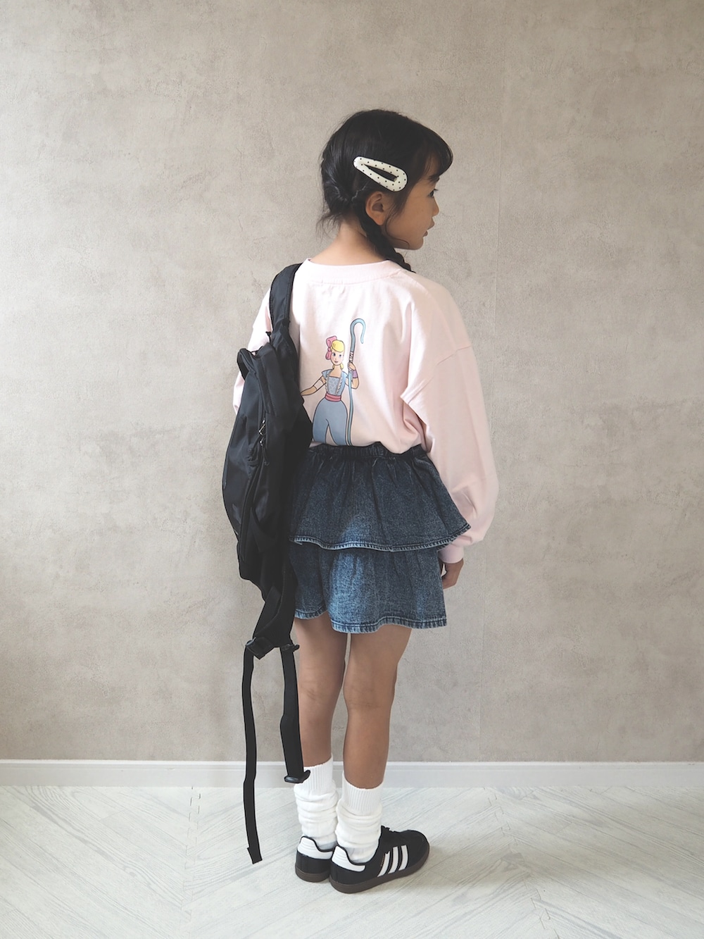 ブラック系のスニーカー、ピンク系のTシャツ/カットソー、ブルー系のデニムパンツを着用したキッズの夏コーディネートの3枚目の写真