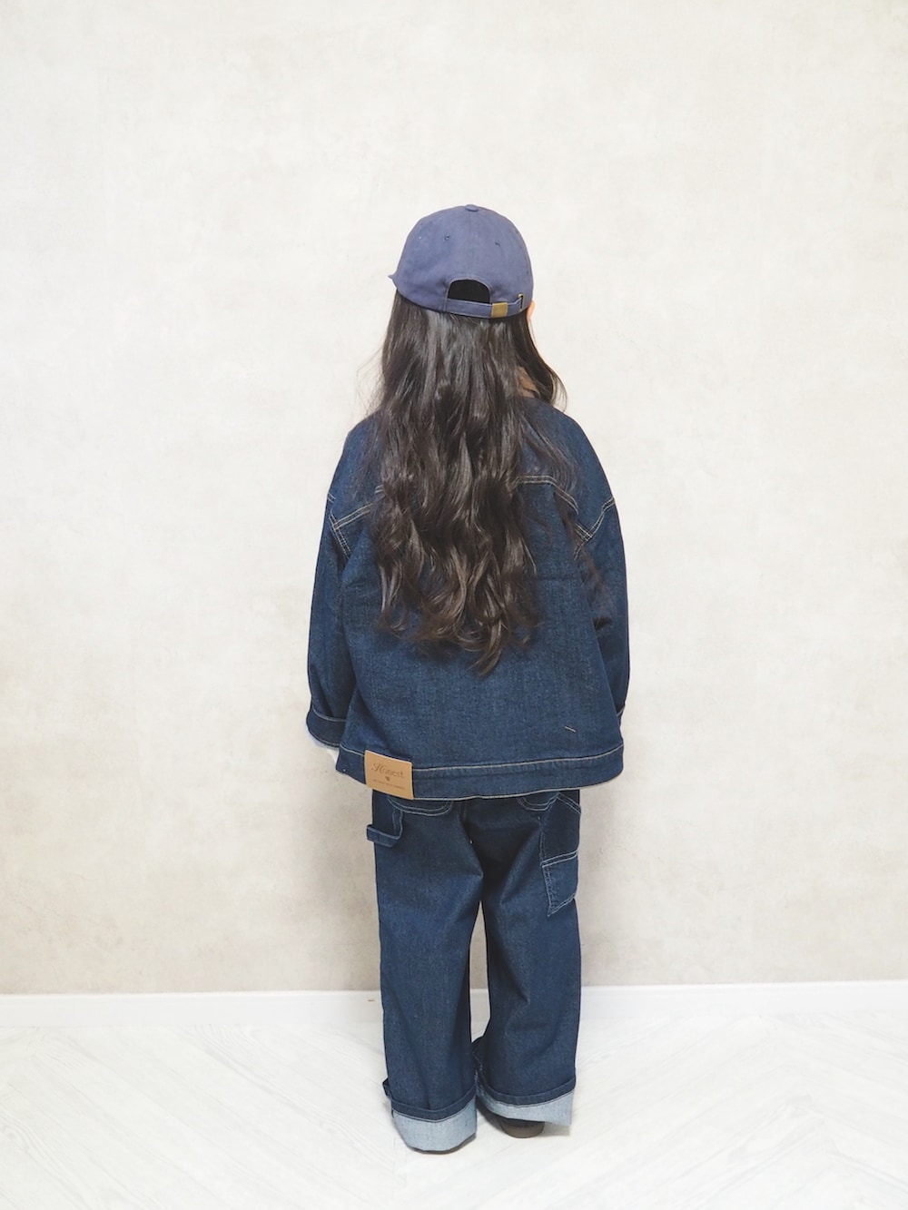 ホワイト系のニット/セーター、ブルー系のデニムパンツ、ブラック系のスニーカーを着用したキッズの冬コーディネートの4枚目の写真