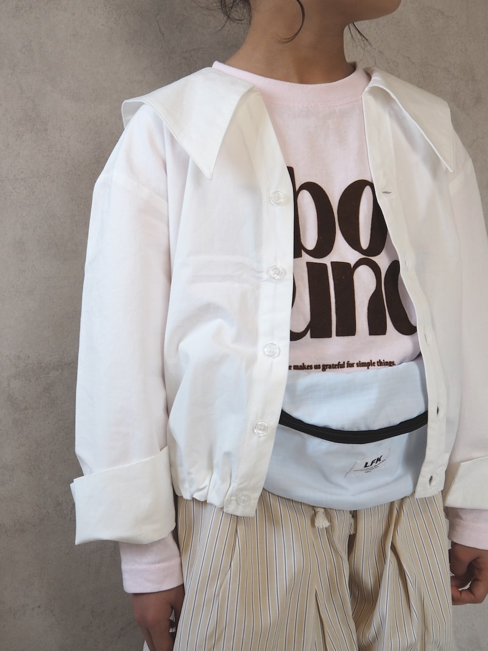 ピンク系のTシャツ/カットソー、ホワイト系のシャツ/ブラウス、ブラック系のスニーカーを着用したキッズの春コーディネートの5枚目の写真