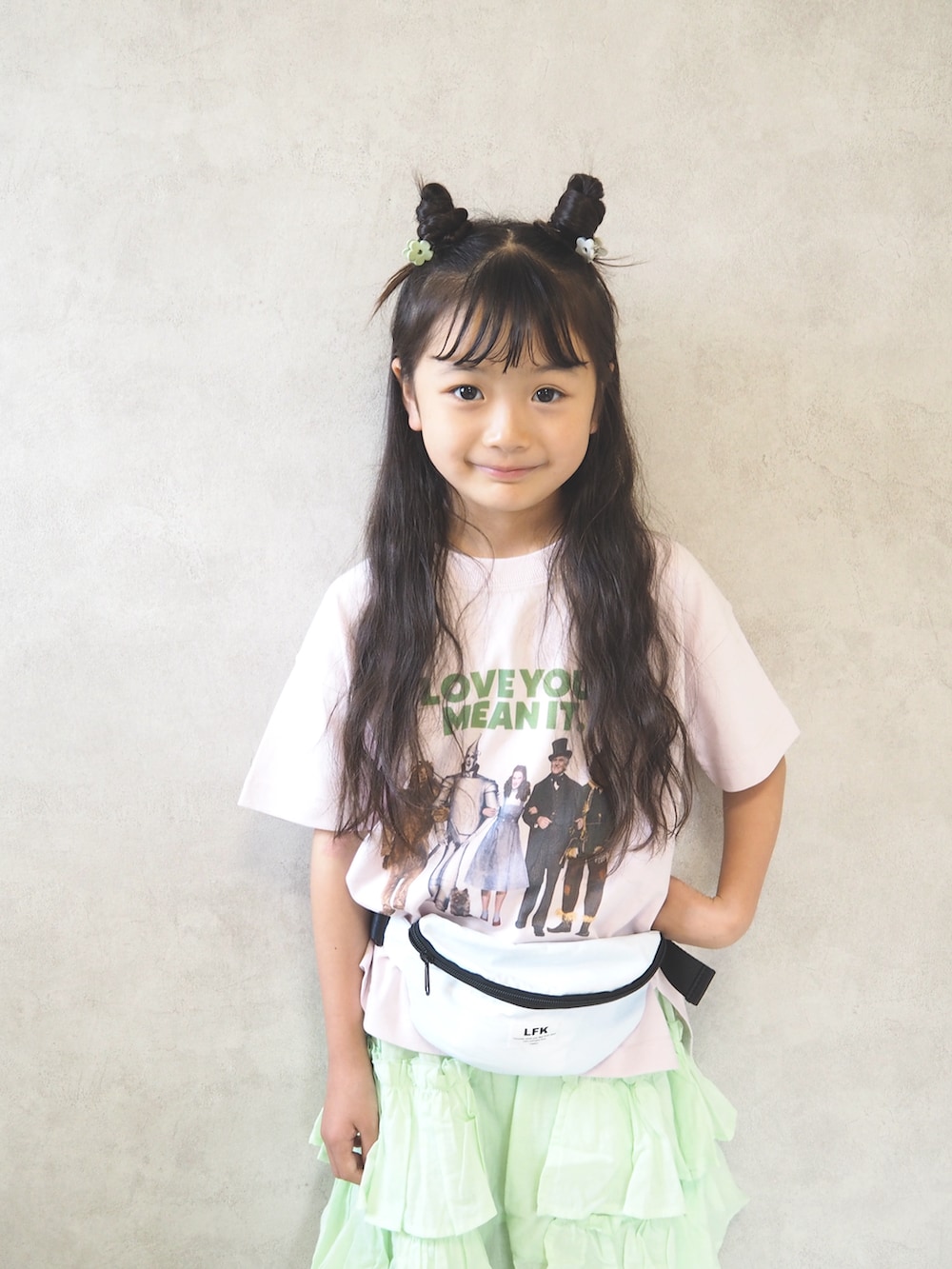 ホワイト系のボディバッグ/ウエストポーチ、ピンク系のTシャツ/カットソー、グリーン系のスカートを着用したキッズの夏コーディネートの3枚目の写真