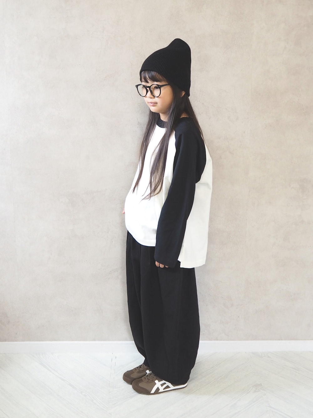 ブラック系のその他パンツ、ホワイト系のTシャツ/カットソー、ブラウン系のスニーカーを着用したキッズの秋コーディネートの3枚目の写真