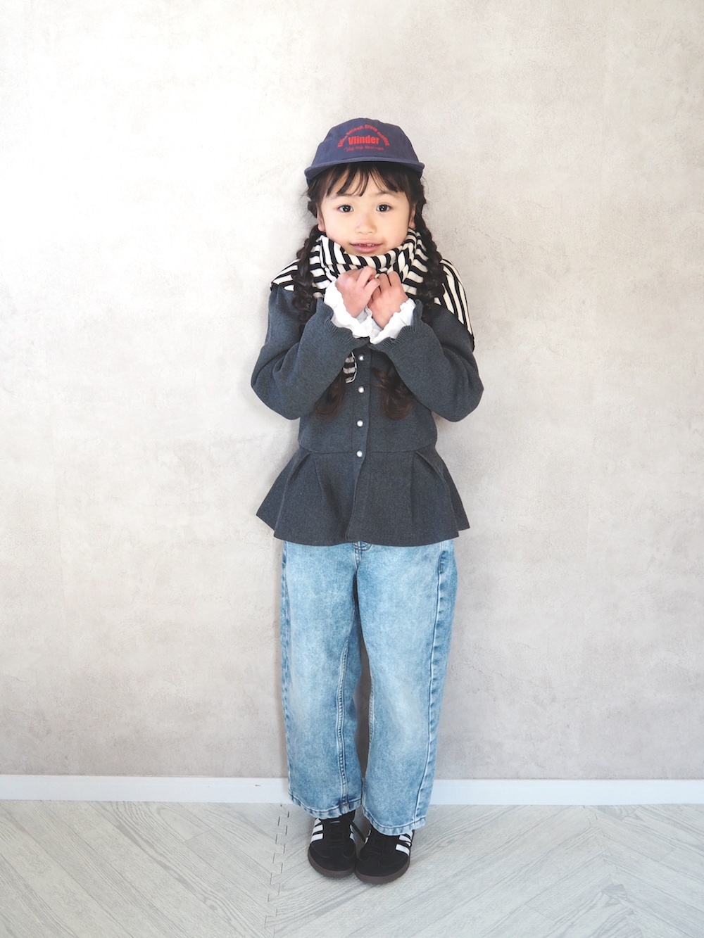 ブラック系のスニーカー、グレー系のカーディガン/ボレロ、ブルー系のキャップを着用したキッズの冬コーディネートの2枚目の写真