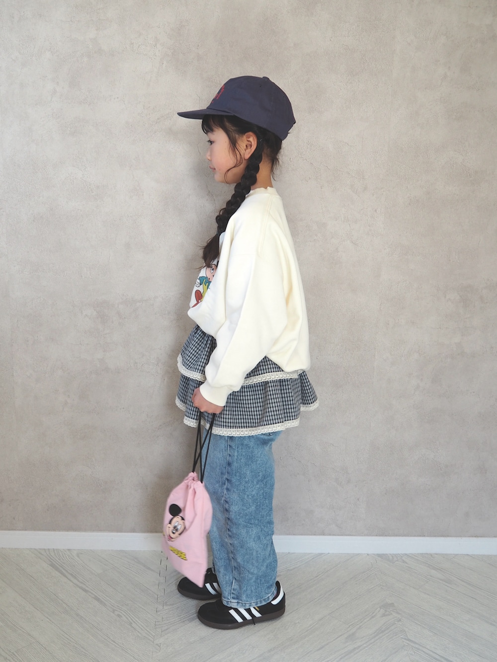 ブラック系のスニーカー、ホワイト系のスウェット、ブラック系のベルトを着用したキッズの春コーディネートの2枚目の写真