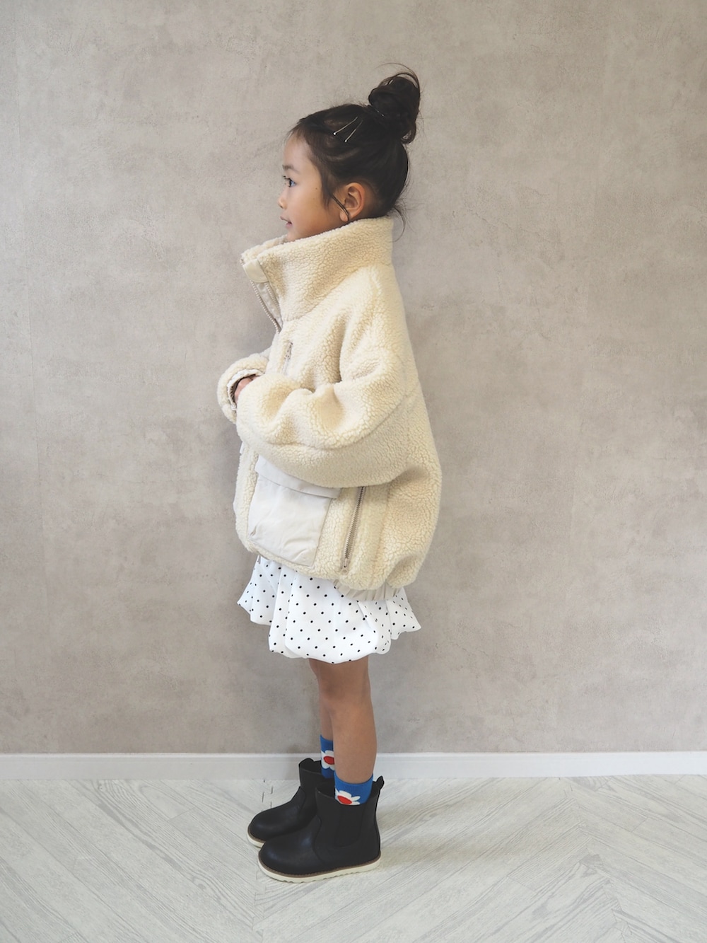 ホワイト系のブルゾン、ホワイト系のスカート、ホワイト系のTシャツ/カットソーを着用したキッズの冬コーディネートの4枚目の写真