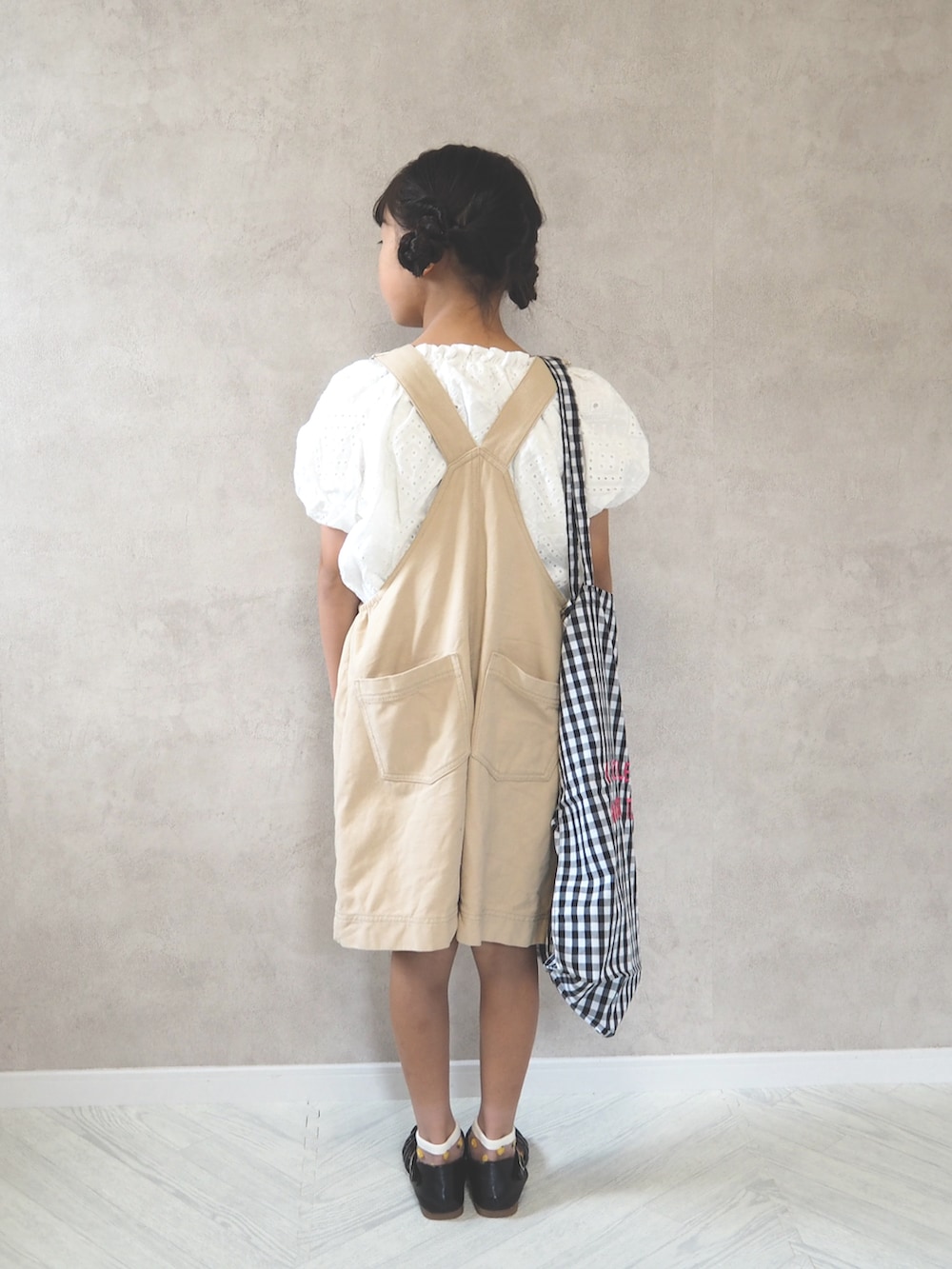 ホワイト系のシャツ/ブラウス、ベージュ系のサロペット/オーバーオール、ブラック系のトートバッグを着用したキッズの夏コーディネートの4枚目の写真