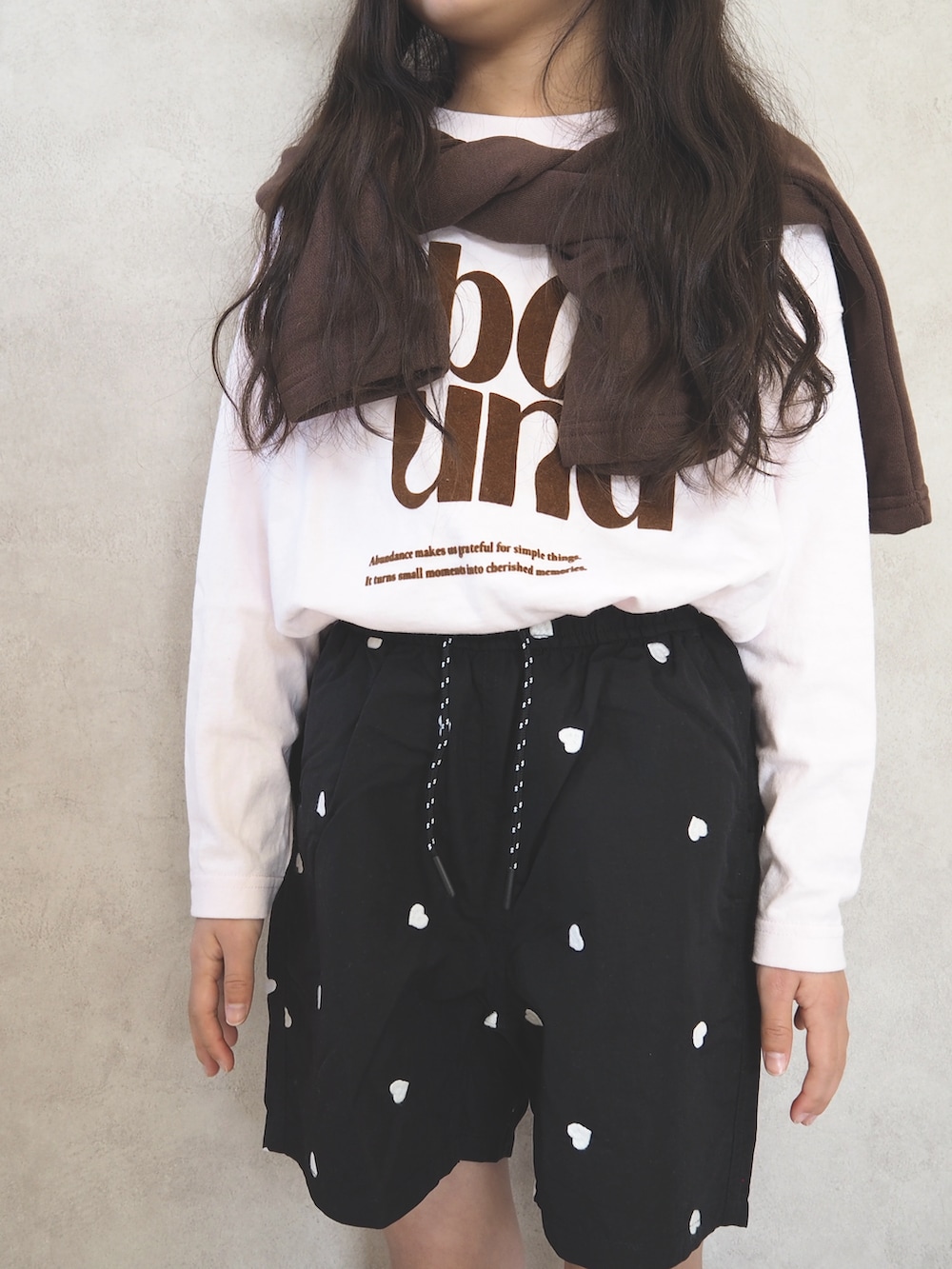 ブラウン系のカーディガン/ボレロ、ピンク系のTシャツ/カットソー、ブラック系のその他パンツを着用したキッズの春コーディネートの4枚目の写真