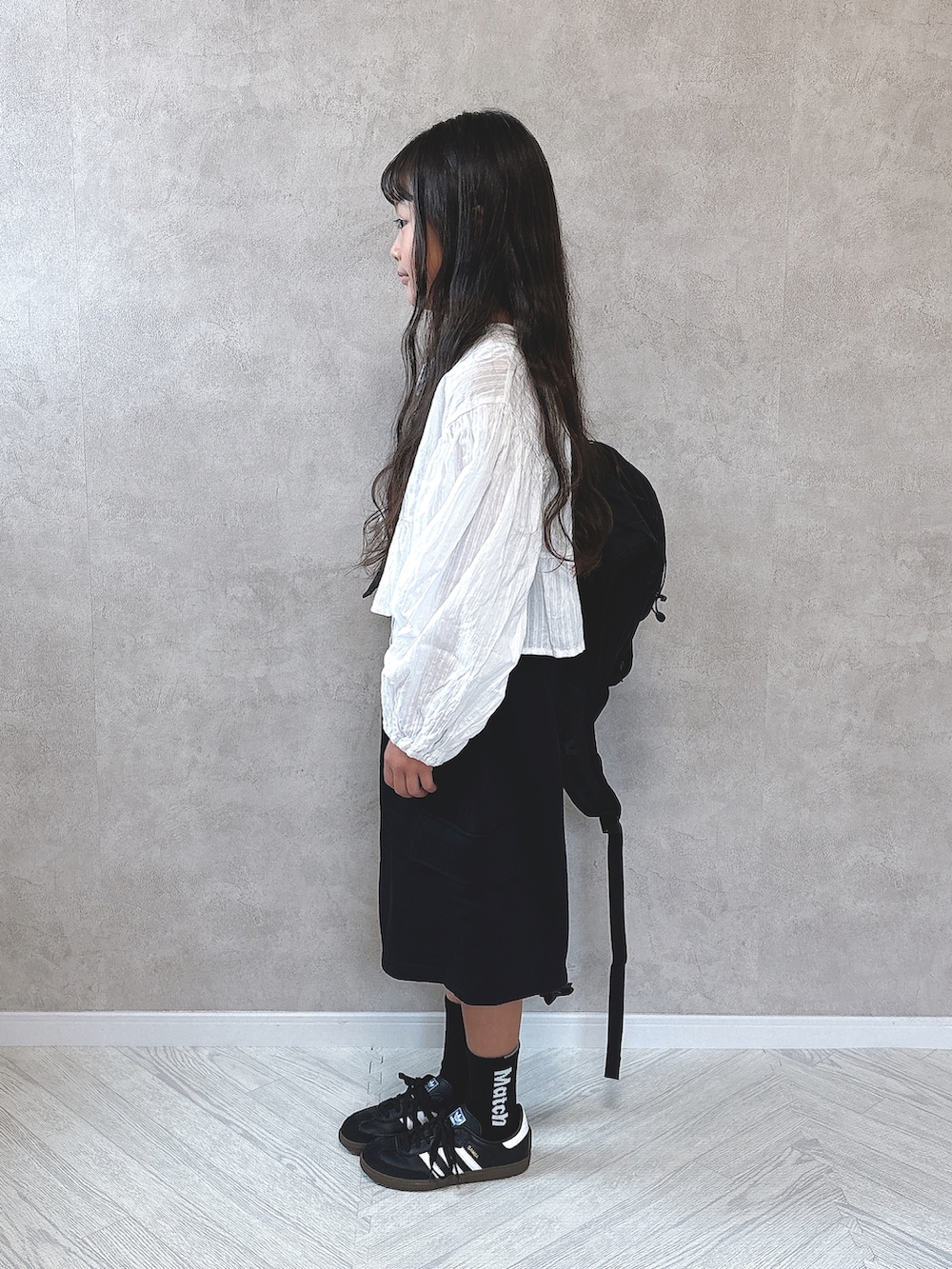ブラック系のその他パンツ、ブラック系のスニーカー、ブラウン系のタンクトップを着用したキッズの秋コーディネートの3枚目の写真