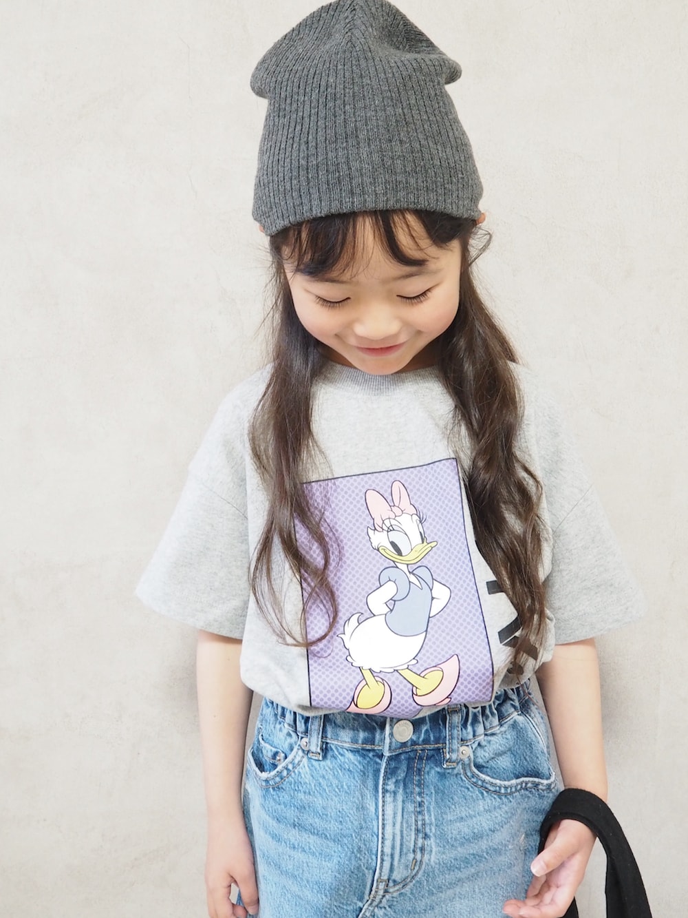 グレー系のTシャツ/カットソー、ブルー系のデニムスカート、ブラック系のスニーカーを着用したキッズの春コーディネートの4枚目の写真
