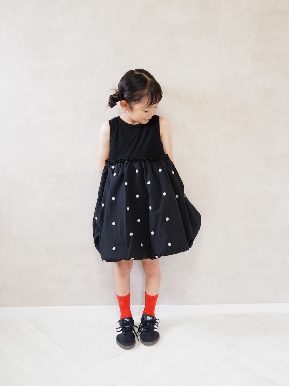 ブラック系のスニーカー、ブラック系のワンピース、レッド系のソックス/靴下を着用したキッズの夏コーディネートの3枚目の写真
