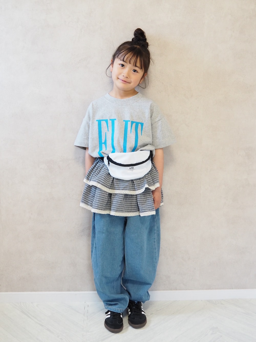 ブラック系のスニーカー、グレー系のTシャツ/カットソー、ブルー系のデニムパンツを着用したキッズの春コーディネートの2枚目の写真