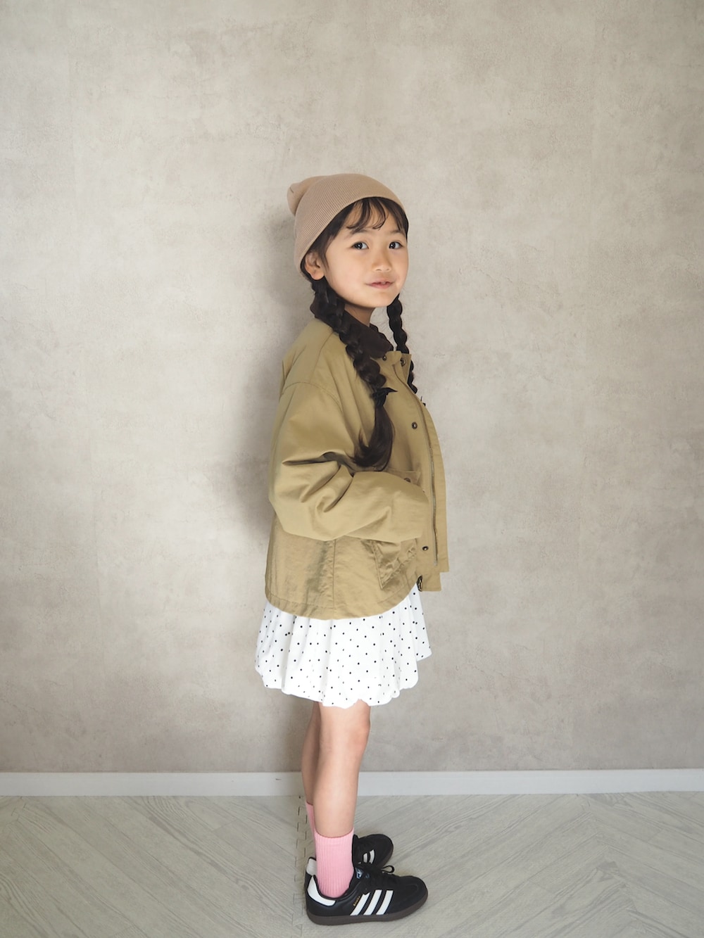 ホワイト系のスカート、ブラック系のスニーカー、グレー系のTシャツ/カットソーを着用したキッズの冬コーディネートの3枚目の写真