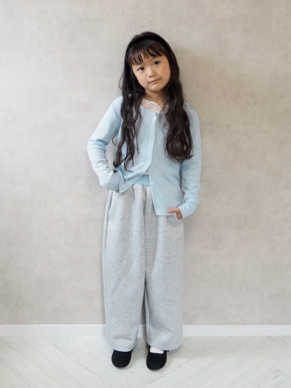ブラック系のバレエシューズ、ブルー系のカーディガン/ボレロ、グレー系のスウェットパンツを着用したキッズの秋コーディネートの2枚目の写真