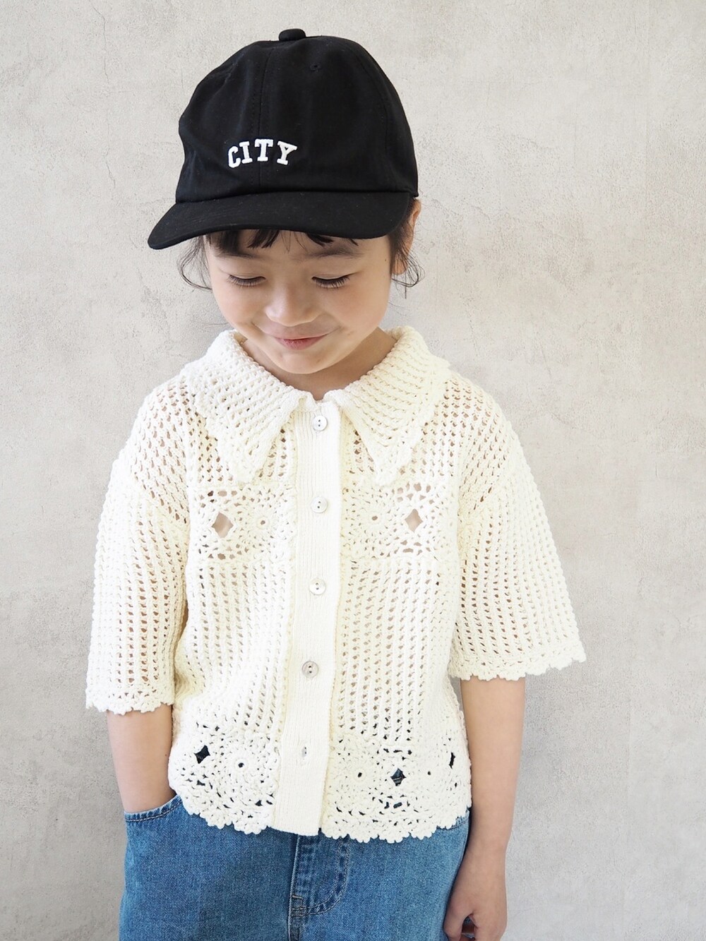 ブルー系のパンツ、ホワイト系のカーディガン/ボレロ、ブラック系のスニーカーを着用したキッズの春コーディネートの2枚目の写真