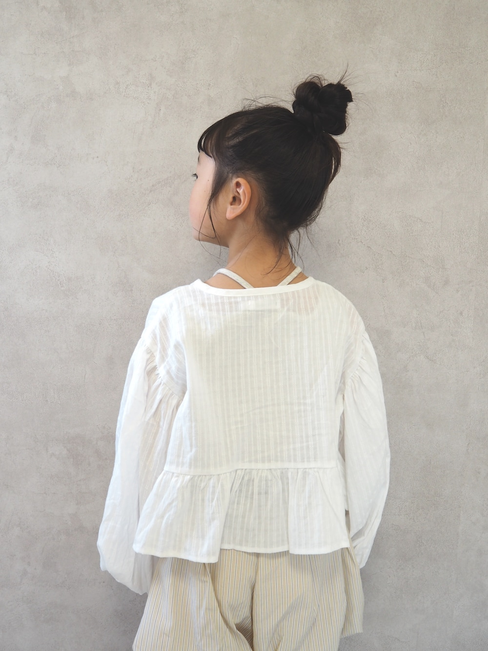 ホワイト系のカーディガン/ボレロ、ホワイト系のタンクトップ、ベージュ系のその他パンツを着用したキッズの春コーディネートの5枚目の写真