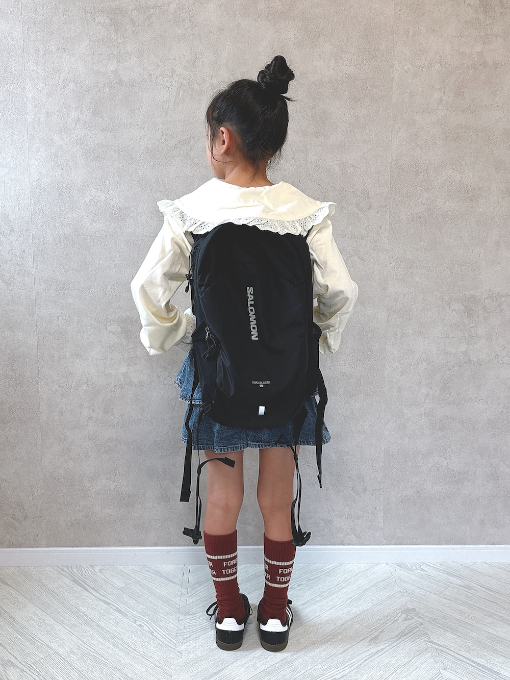 ブルー系のデニムパンツ、ブラック系のスニーカー、ホワイト系のTシャツ/カットソーを着用したキッズの秋コーディネートの3枚目の写真
