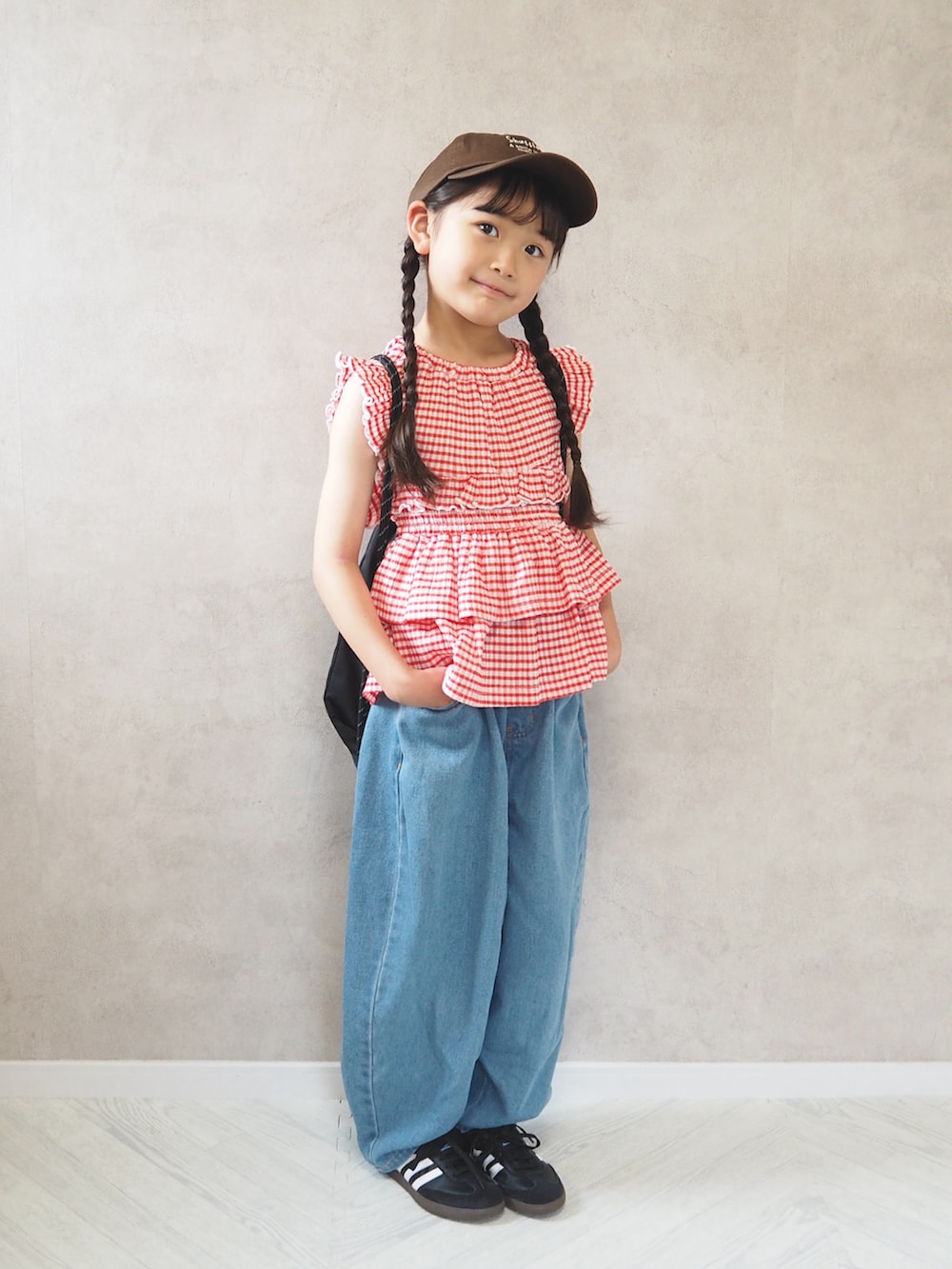 ブラック系のスニーカー、レッド系のTシャツ/カットソー、ブルー系のデニムパンツを着用したキッズの夏コーディネートの2枚目の写真