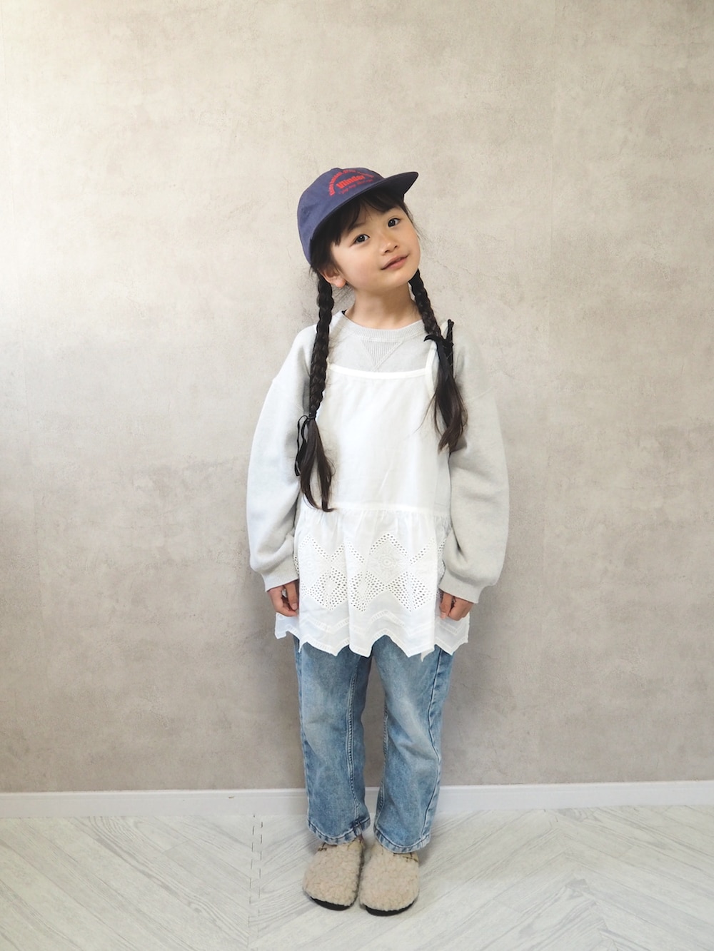 ホワイト系のニット/セーター、ホワイト系のサンダル、ブラック系のバックパック/リュックを着用したキッズの冬コーディネートの5枚目の写真