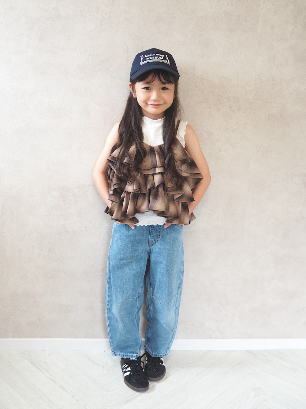 ブラウン系のキャミソール、ブルー系のパンツ、ブルー系のキャップを着用したキッズの夏コーディネートの2枚目の写真
