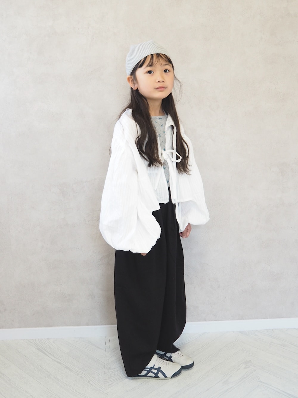 ブラック系のその他パンツ、ホワイト系のカーディガン/ボレロ、グレー系のタンクトップを着用したキッズの春コーディネートの2枚目の写真
