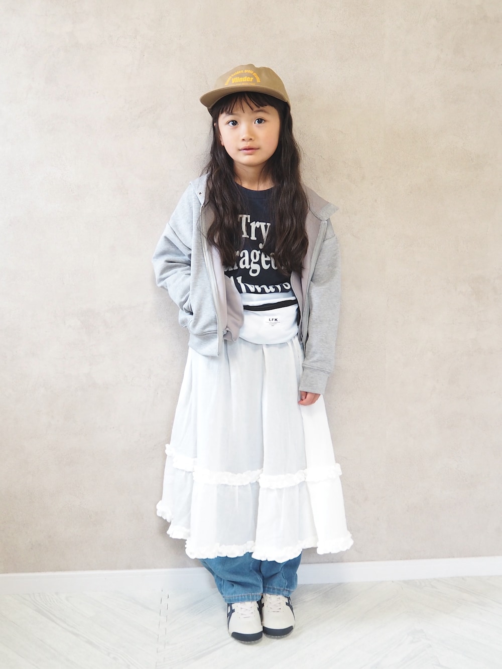 ブルー系のTシャツ/カットソー、ホワイト系のスカート、グレー系のパーカーを着用したキッズの春コーディネートの2枚目の写真