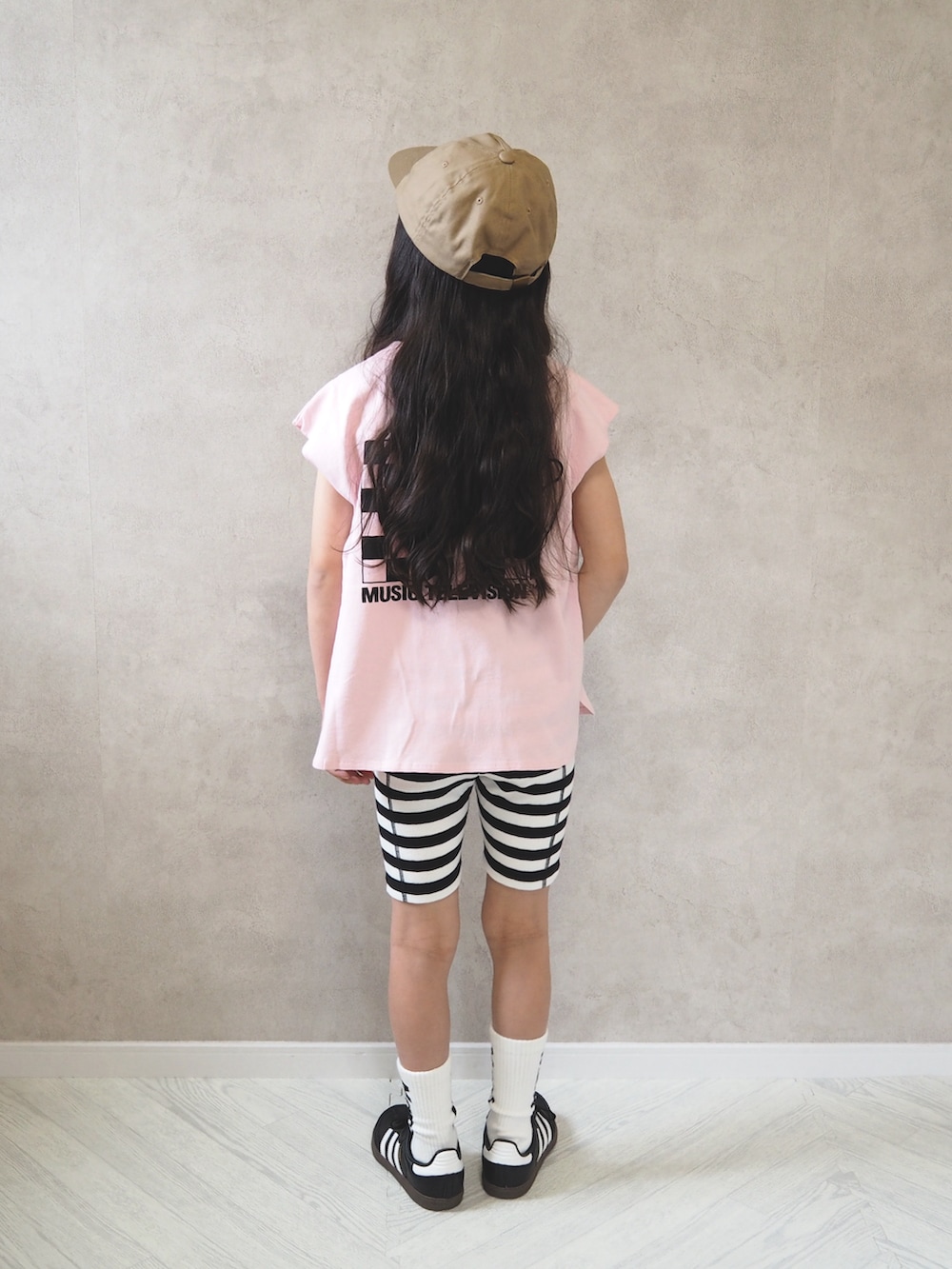 ブラック系のスニーカー、ピンク系のTシャツ/カットソー、ゴールド系のキャップを着用したキッズの春コーディネートの4枚目の写真